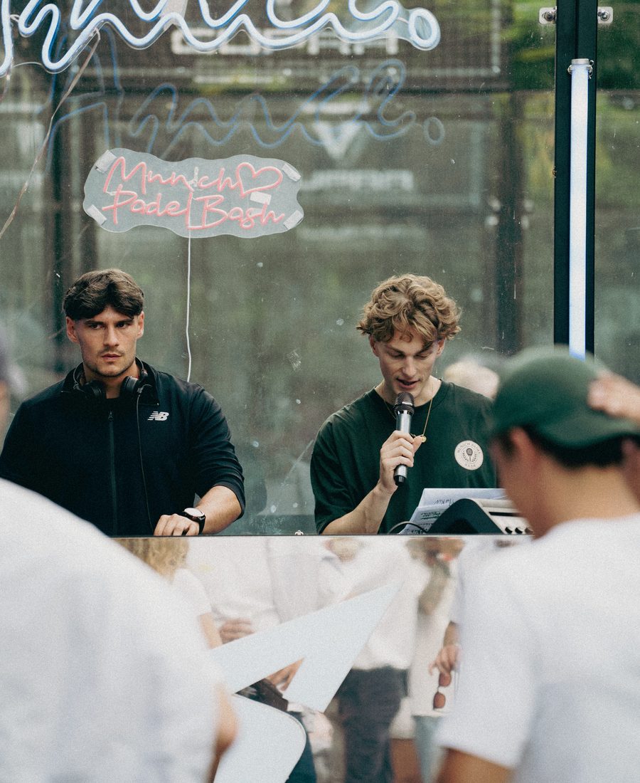 Live host and DJ under the Munich Padel Bash neon sign